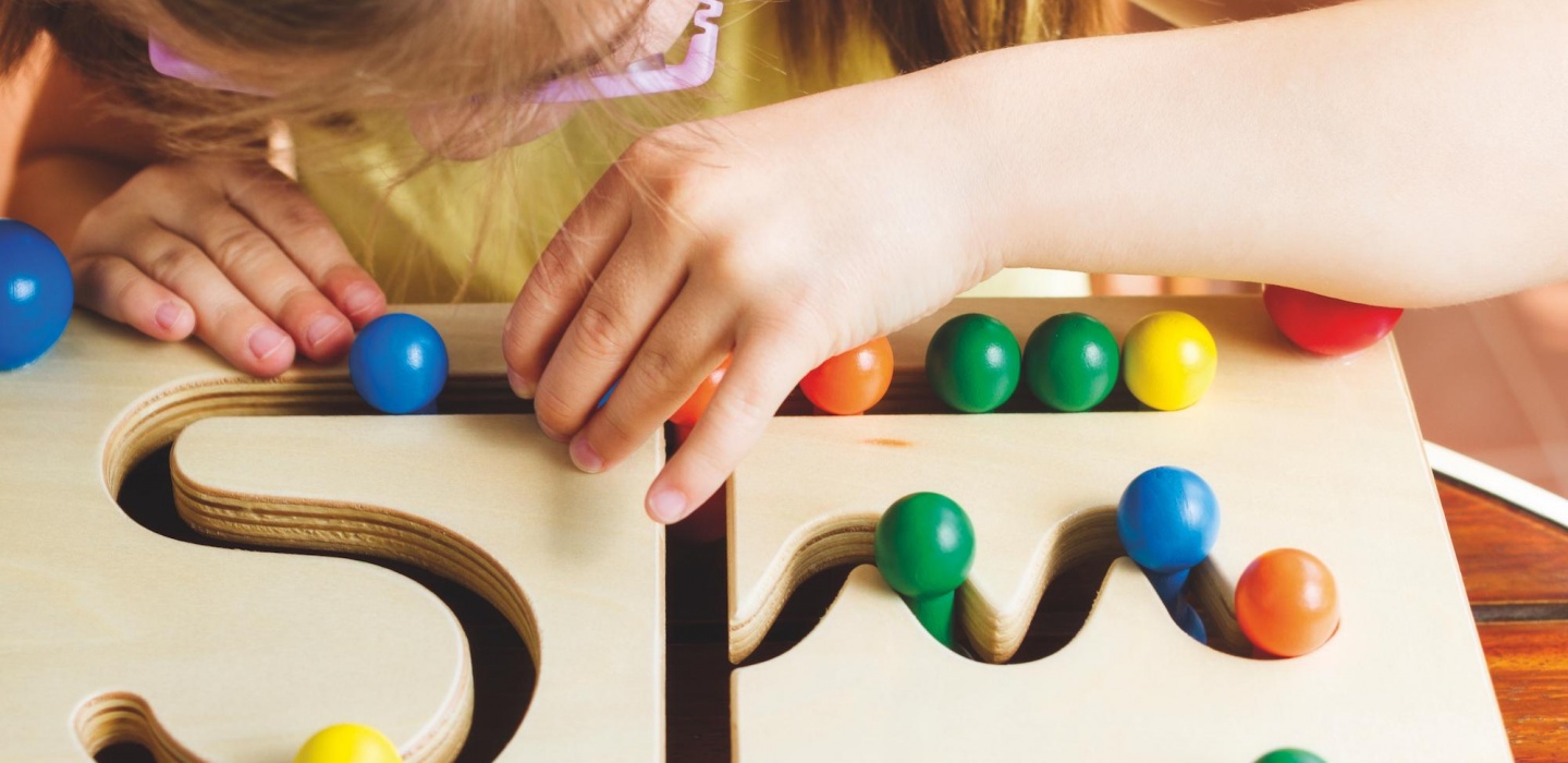 A child is using crayons to draw