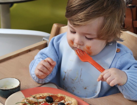 A happy child is looking at a healthy desert in children's cafe at Cloud Twelve